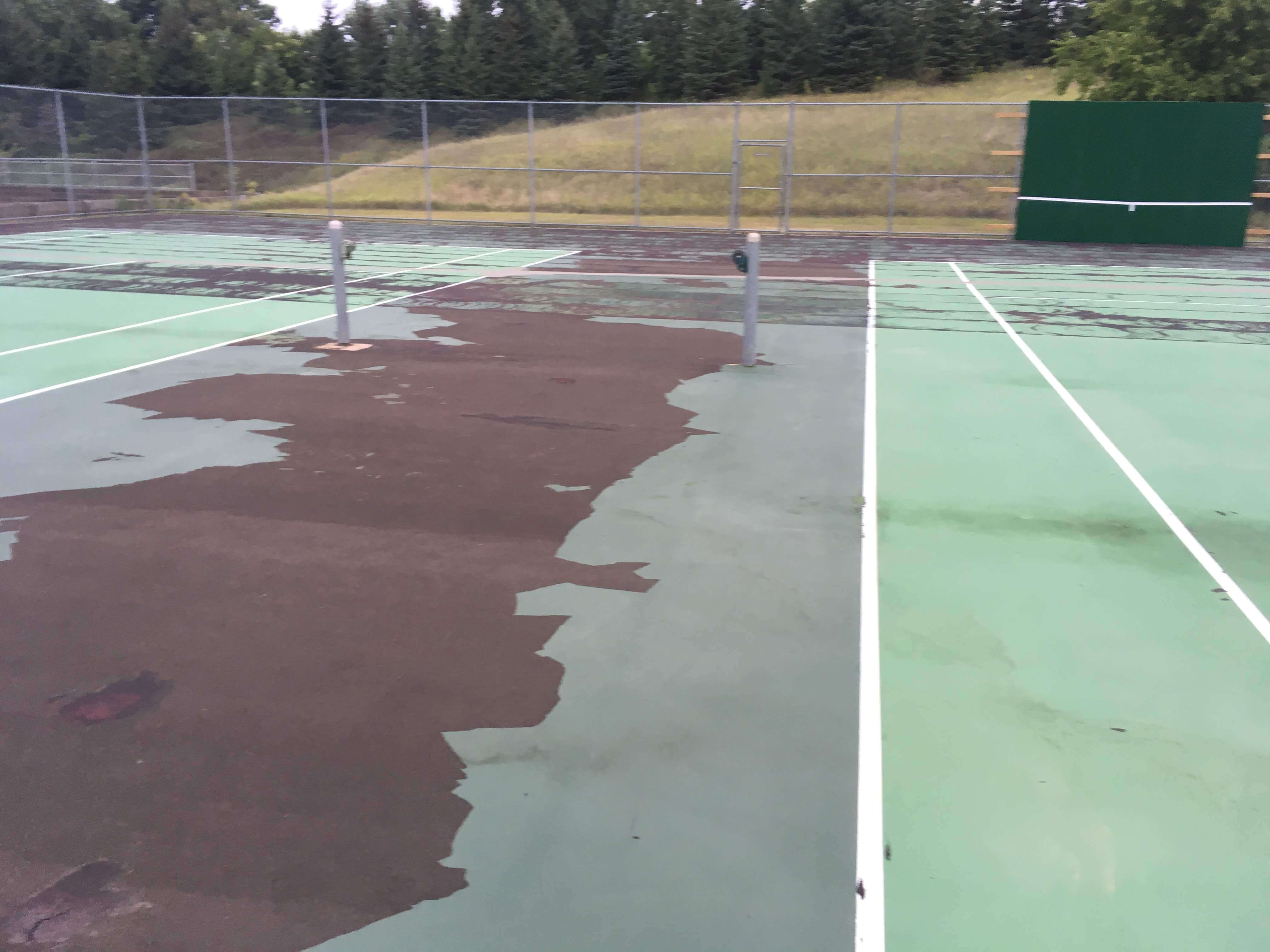 Tennis court BEFORE completed resurfacing and crack repair by C & H Sport Surfaces, Inc