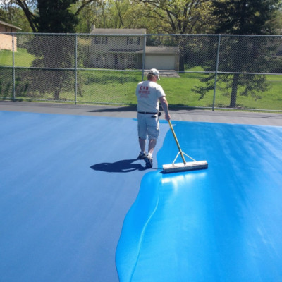 Adding blue to the tennis court surface during the resurfacing stage