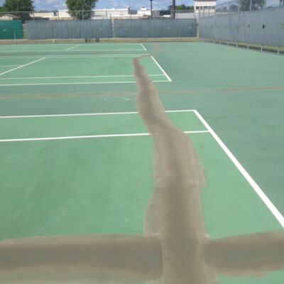 Crack repair of a tennis court before Maintenace