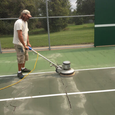 Sanding the court surface to get ready for repairs